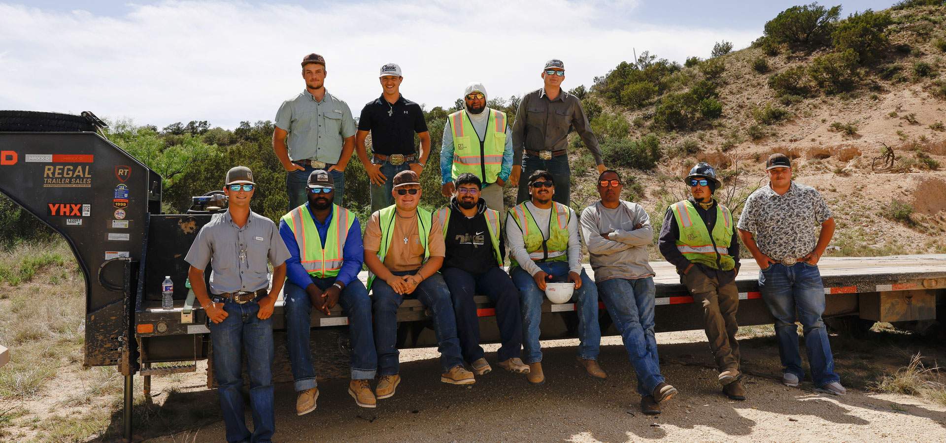 American Land Clearing Co. crew gathered on a flatbed trailer at a West Texas job site